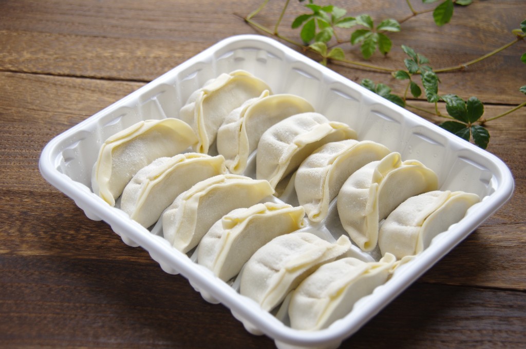 白いトレーに並んだ生の餃子